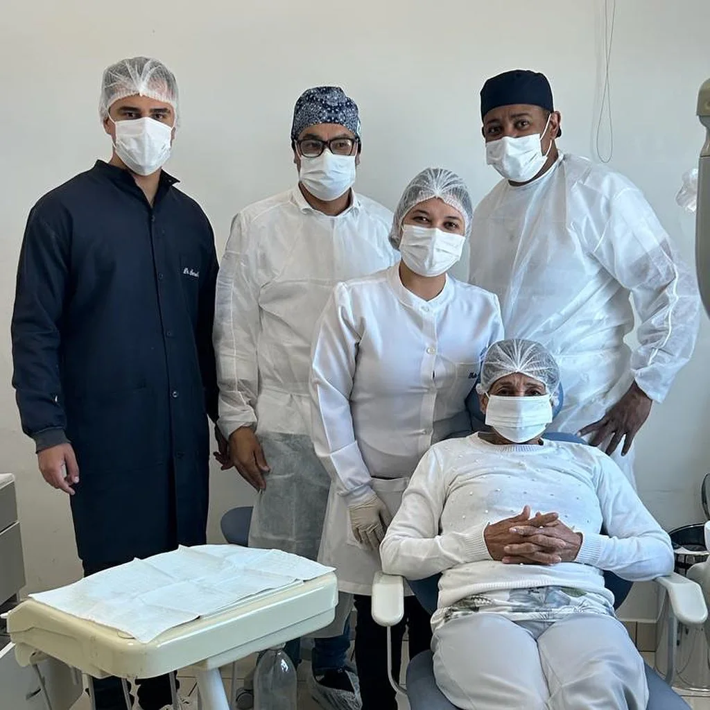 Equipe odontológica em atendimento com paciente